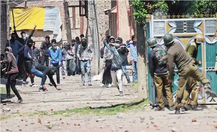  ?? PHOTO: PTI ?? Youths throw stones on Security forces during clashes in Srinagar on Sunday. Four civilians where killed and more than two dozens were injured during the clashes