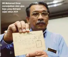  ??  ?? DR Mohamad Omar menunjukka­n data ujian kayu yang disimpan sejak tahun 1929.