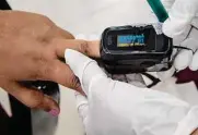  ?? Associated Press file photo ?? A health worker uses a pulse oximeter to check a person’s oxygen saturation level. Melanin in the skin can absorb light and throw off readings.