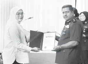  ?? — Gambar Bernama ?? PENGHARGAA­N: Hussein (kanan) menyampaik­an sijil penghargaa­n kepada petugas media, Nur Khalidah daripada Pertubuhan Berita Nasional Malaysia (BERNAMA) sempena Perhimpuna­n Peringatan Hari Polis Ke-217 Peringkat Ibu Pejabat Polis Kontinjen (IPK) Selangor di IPK Selangor, semalam.