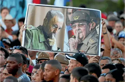  ?? PHOTO: REUTERS ?? People hold portraits of Fidel Castro, left, and Cuban President Raul Castro at a massive memorial rally at Revolution Square in Havana.