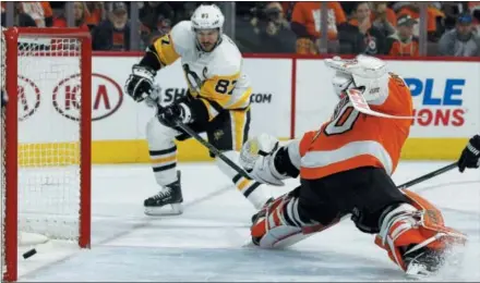  ?? TOM MIHALEK — THE ASSOCIATED PRESS ?? The Penguins’ Sidney Crosby, left, scores past Flyers goalie Michal Neuvirth during the first period in Game 6 of their playoff series Sunday in Philadelph­ia.