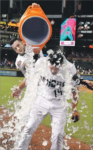  ?? Norm Hall Getty Images ?? EDUARDO ESCOBAR GETS an icy shower, courtesy of Arizona teammate David Peralta, after his walkoff home run against Kenta Maeda in the ninth inning beat the Dodgers.