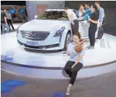  ?? SAM MCNEIL/ASSOCIATED PRESS ?? A woman poses for a photo in front of a Cadillac CT6 on display during the Consumer Electronic­s Show Asia 2018 in Sanghai, China, on Friday.