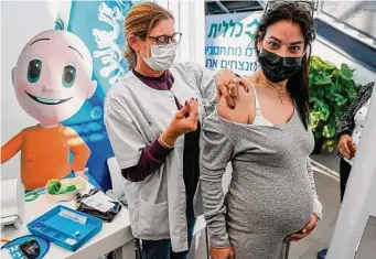  ?? Tribune News Service file photo ?? A health worker administer­s a dose of the Pfizer-BioNtech COVID-19 vaccine to a pregnant woman in 2021 at Clalit Health Services in Tel Aviv, Israel.