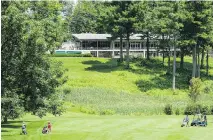  ?? FREDERICH ORE, MONTRE-AL GAZETTE FILES ?? Golfers walk the lush fairway below the clubhouse of the Whitlock Golf and Country Club in Hudson. Establishe­d in 1912 as a nine- hole course, today it has 27 challengin­g links on 400 acres of land.