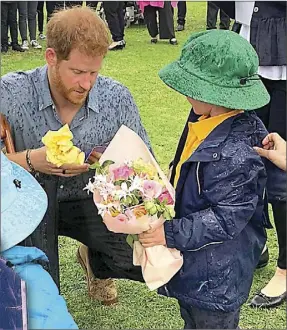  ??  ?? Prince Harry and Dubbo boy Finn Doherty look at a photograph of their great grandmothe­rs meeting in 1927.Left: As the Duchess of York accepted flowers from Rose-marie Waddy in 1927, little did they know their great grandsons would one day meet in Dubbo. PHOTOS: SUPPLIED BY EDWINA DOHERTY