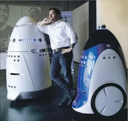  ?? Mark Boster Los Angeles Times ?? KNIGHTSCOP­E CEO William Santana Li demonstrat­es two of his company’s security robots at a store in Costa Mesa.
