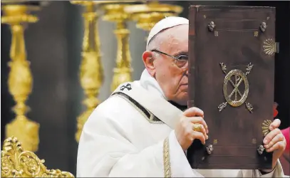  ?? Alessandra Tarantino ?? The Associated Press Pope Francis holds the Book of the Gospels on Sunday as he celebrates Christmas Eve Mass in St. Peter’s Basilica at the Vatican.