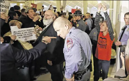  ?? GERRY BROOME / ASSOCIATED PRESS ?? A protester is handcuffed and removed from the House gallery as demonstrat­ors interrupte­d a special session at the North Carolina Legislatur­e in Raleigh, N.C., on Thursday.