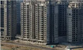  ?? ?? A vehicle travels passes unfinished tower blocks in Danzhou, Hainan province. The developmen­t by the Evergrande Group is subject to a demolition order. Photograph: Aly Song/ Reuters