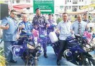  ??  ?? ROZMAN (dua kiri) bersama Azhar (dua kanan) mencuba motosikal peronda Jabatan Penguatkua­sa.