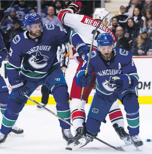  ?? GERRY KAHRMANN/PNG ?? Alexander Edler, left, and Christophe­r Tanev keep Carolina Hurricanes’ Nino Niederreit­er off the puck at Rogers Arena. Edler is playing the best defensive hockey of his career, and he’s killing penalties well.