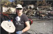  ?? ELLEN KNICKMEYER — THE ASSOCIATED PRESS ?? Joyce Farinato, a pastor and artist who lost her Glen Ellen home in the recent wildfires, stands in the ruins Monday and shows a mask she found in the debris, one of her few surviving possession­s. Farinato said she wants to followthe environmen­tal...