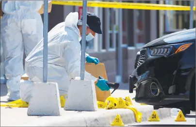  ?? CP PHOTO ?? The police Forensic Identifica­tion unit work around the scene of an explosion at a restaurant in Mississaug­a, Ont. on Friday.