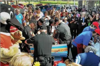 ?? DIGITAL FIRST MEDIA FILE PHOTO ?? Customers on hand for the 2015 opening of the Wawa store on Grosser Road in Douglass (Mont.), watch the Douglass Township Police Department, left, and the Gilbertsvi­lle Fire Company compete to see which group could build the most hoagies in three...