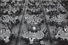  ??  ?? Players and dealers sit at tables during a tournament at the World Series of Poker in Las Vegas ahead of the main event, which will kick off July 3. aP-John locher, File