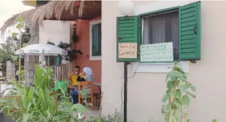  ??  ?? Ahmad Berajikli drinks coffee from a cup as he and his family stay in a former Peloponnes­e tourist resort that has been turned into migrant housing near the town of Myrsini, southwest of Athens, last week.