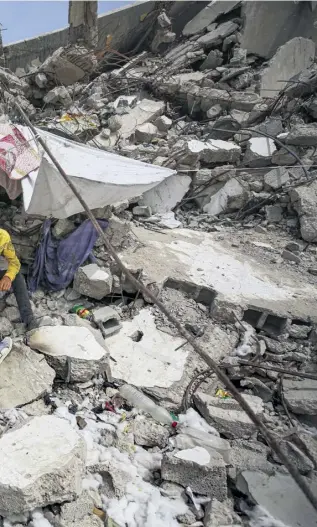  ?? PHOTOGRAPH: DAWOUD ABO ALKAS/GETTY IMAGES ?? Palestinia­ns take shelter in northern Gaza amid the ruins of buildings hit by Israeli attacks