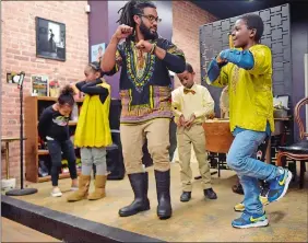  ?? SARAH GORDON/THE DAY ?? Josh Brown, center, works on teaching a step routine to Parrish Boyd, 8, of New London during a Kwanzaa celebratio­n on Sunday in New London.