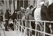  ?? John Locher / Associated Press file photo ?? People wait in line for help with unemployme­nt benefits at the One-stop Career Center in Las Vegas in this photograph from March.