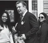  ?? STEVE HELBER/AP ?? Alec Baldwin and Democratic candidate Amanda Pohl, right, knock on doors Tuesday in Virginia.