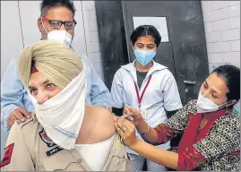  ?? PTI ?? A health worker administer­s a Covid-19 vaccine to a police officer in Patiala on Wednesday.