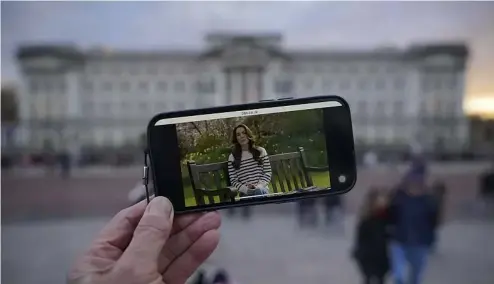  ?? ?? A person watches an announceme­nt on a smart phone outside Buckingham Palace by Kate, the Princess of Wales, Friday, March 22, 2024.