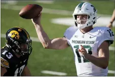  ?? CHARLIE NEIBERGALL — THE ASSOCIATED PRESS ?? Michigan
State quarterbac­k Rocky Lombardi (12) throws a pass over Iowa defensive end Joe Evans (13) during the second half of a Nov. 7 game in Iowa City, Iowa. Iowa won 49-7.