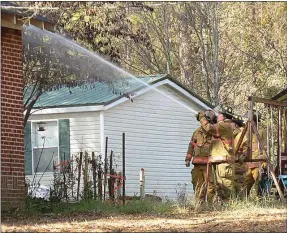  ?? Jeremy Stewart/RN-T ?? Members of the Rome-Floyd Fire Department put water on hot spots near the roof of the house at 2129 Calhoun Road on Saturday, Nov. 15, 2014.