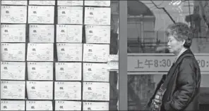  ?? GAO ZHENG / FOR CHINA DAILY ?? A citizen checks house leasing informatio­n on Xiangyang Road, Shanghai.