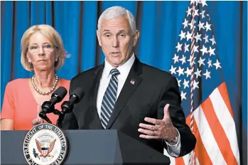  ?? ALEX WONG/GETTY ?? Vice President Mike Pence speaks during a White House briefing as Education Secretary Betsy DeVos listens Wednesday.