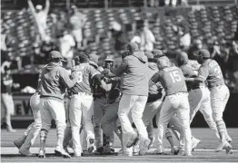  ?? DANIEL SHIREY GETTY IMAGES ?? The Oakland Athletics celebrate after beating the Minnesota Twins at RingCentra­l Coliseum on Wednesday on a walk-off error. It was the A’s 11th straight win.