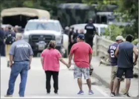  ?? ELIZABETH CONLEY — HOUSTON CHRONICLE VIA AP ?? Family members hold hands as recovery efforts were underway for a van with 6 family whose bodies were were found in a van at Greens Bayou in east Houston, after Tropical Storm Harvey left the Houston area on Wednesday in Houston.