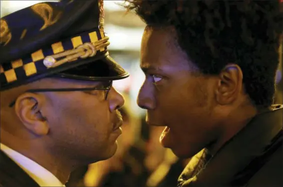  ?? CHARLES REX ARBOGAST — THE ASSOCIATED PRESS ?? Lamon Reccord, right, stares and yells, “Shoot me 16 times,” at a Chicago police officer as he and others march through Chicago’s Loop, one day after murder charges were brought against police officer Jason Van Dyke in the killing of 17-year-old Laquan McDonald.