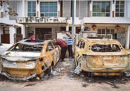  ?? (Foto BERNAMA) ?? Penduduk memeriksa kediaman dan kenderaan yang musnah di Jalan Putra Harmoni, Putra Heights, semalam.