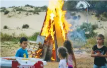  ?? (Flash90) ?? CHILDREN GATHER around a bonfire to celebrate Lag Ba’omer in Ashdod in 2018.