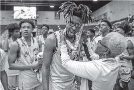  ?? AL DIAZ adiaz@miamiheral­d.com ?? Calvary Christian forward Gregg Glenn gets his state championsh­ip medal and celebrates with teammates after defeating Andrew Jackson for the Class 4A title.