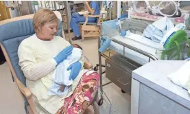  ??  ?? Volunteers hold infants in the newborn intensive care unit at University of Mississipp­i Medical Center in Jackson. CLARION LEDGER FILE PHOTO