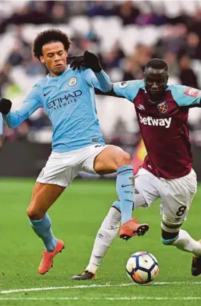  ?? AFP PIC ?? Manchester City’s Leroy Sane (left) and West Ham United’s Cheikhou Kouyate battle for the ball yesterday.