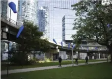  ?? MELISSA RENWICK/TORONTO STAR ?? The circular off ramp at York St. has been a park for some time. This year, a temporary installati­on of blue windsocks was added.