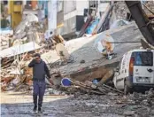  ?? UNAL CAM AP ?? A man walks past debris from destroyed buildings in Antakya, Turkey, on Tuesday.