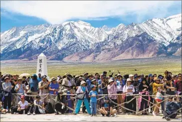  ??  ?? WITH SNOW-TIPPED mountains in the background, visitors line the cemetery area. More than 2,000 traveled to Manzanar to mark the 50th anniversar­y of an annual pilgrimage to the site of the wartime camp.