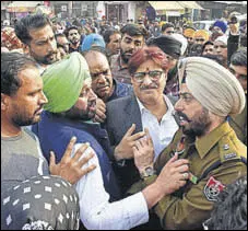  ?? SAMEER SEHGAL/HT ?? Congress councillor Salinderji­t Singh Shally arguing with a police official during a protest outside B-division police station in Amritsar on Monday.