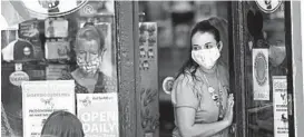  ?? ROBERT F. BUKATY/AP ?? A worker at a Maine shop regulates the number of customers allowed in Thursday.