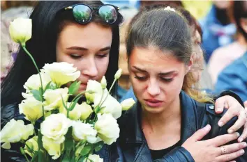  ?? AFP ?? Two girls at a church service for victims of the Kerch Polytechni­c College attack in Crimea yesterday, Teachers and classmates described the attacker as a shy man with few friends.