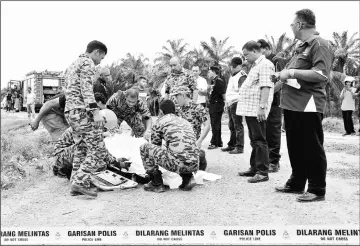  ??  ?? Fire and Rescue personnel carrying the body of Yee Yoon Fah. — Bernama photo