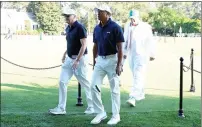  ?? — AFP ?? Tiger Woods leaves the course to enter the Clubhouse after practising a few holes with Rob Mcnamara and caddie Lance Bennett.