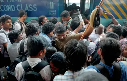  ?? AFP ?? A cop tries to control passengers as they board a crowded train on their way to their hometowns ahead of the festival of Diwali, in Chennai on Friday. —