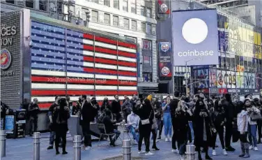  ?? Shannon Stapleton / Reuters ?? Els empleats de Coinbase Global miren la seva cotització a Times Square, a Nova York, dimecres.